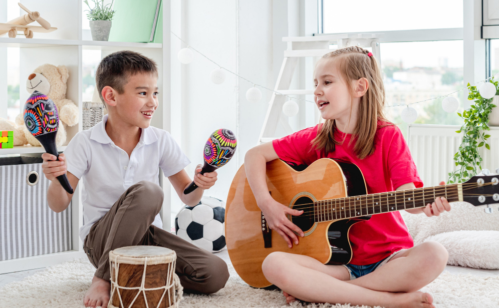 niña y niño tocando instrumento de musica